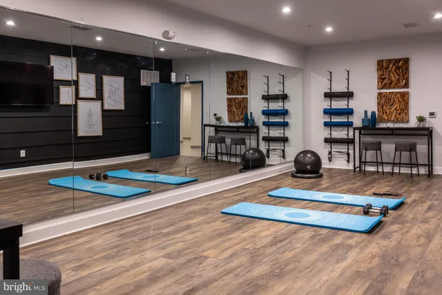 a living room with stainless steel appliances furniture a flat screen tv and kitchen view