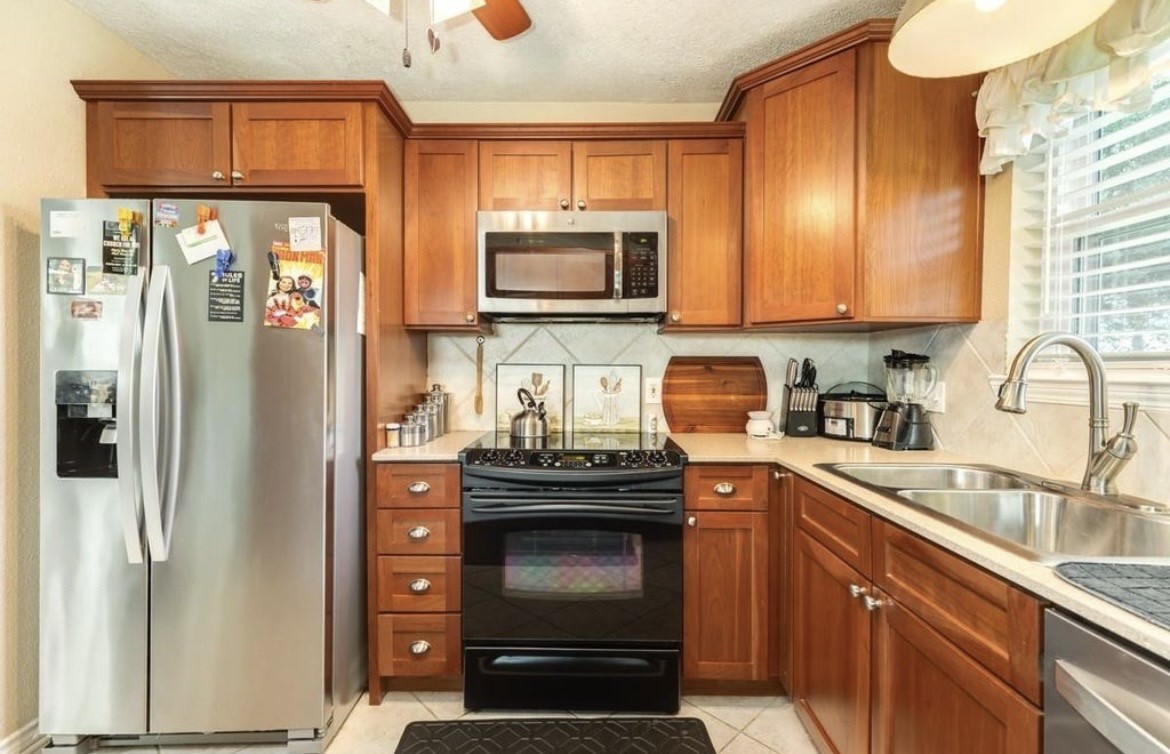 820 Perry Street Angleton, TX 77515 - Photo 18 of 26 a kitchen with stainless steel appliances granite countertop a stove a refrigerator and a sink