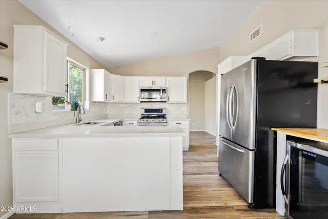 a kitchen with white cabinets sink and appliances
