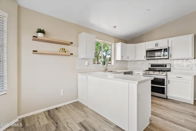 a kitchen with stainless steel appliances a refrigerator sink and cabinets