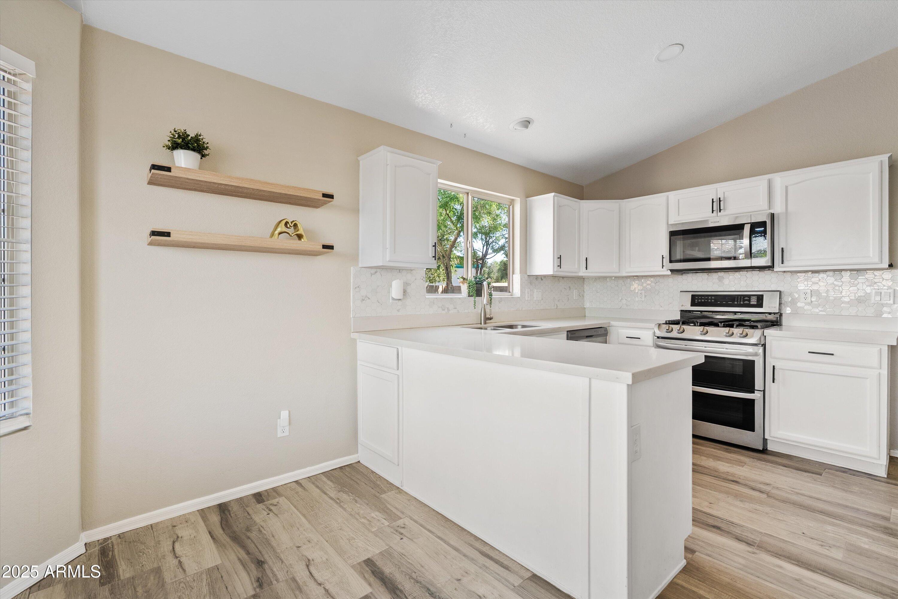 545 South Ash Street Gilbert, AZ 85233 - Photo 11 of 38 a kitchen with a sink a window a refrigerator and a stove top oven
