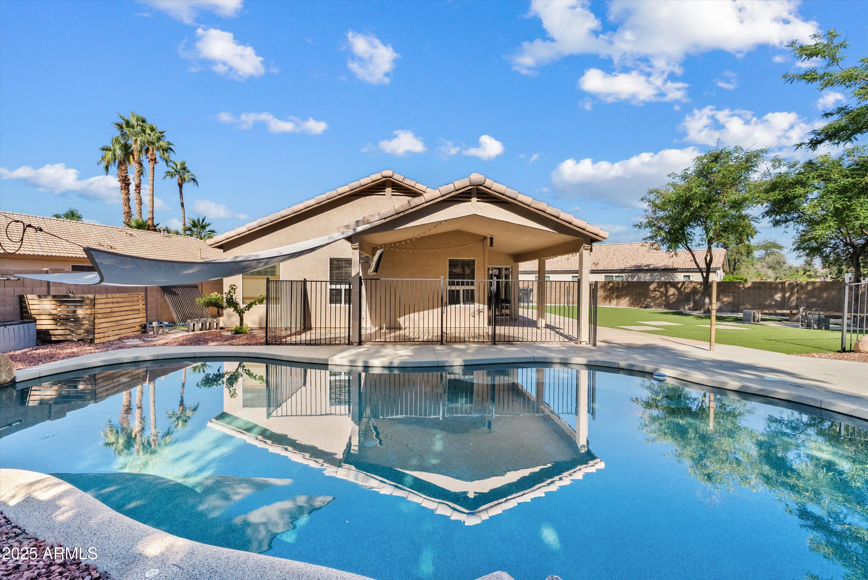 545 South Ash Street Gilbert, AZ 85233 - Photo 29 of 38 a view of a house with pool lawn chairs and a fire pit