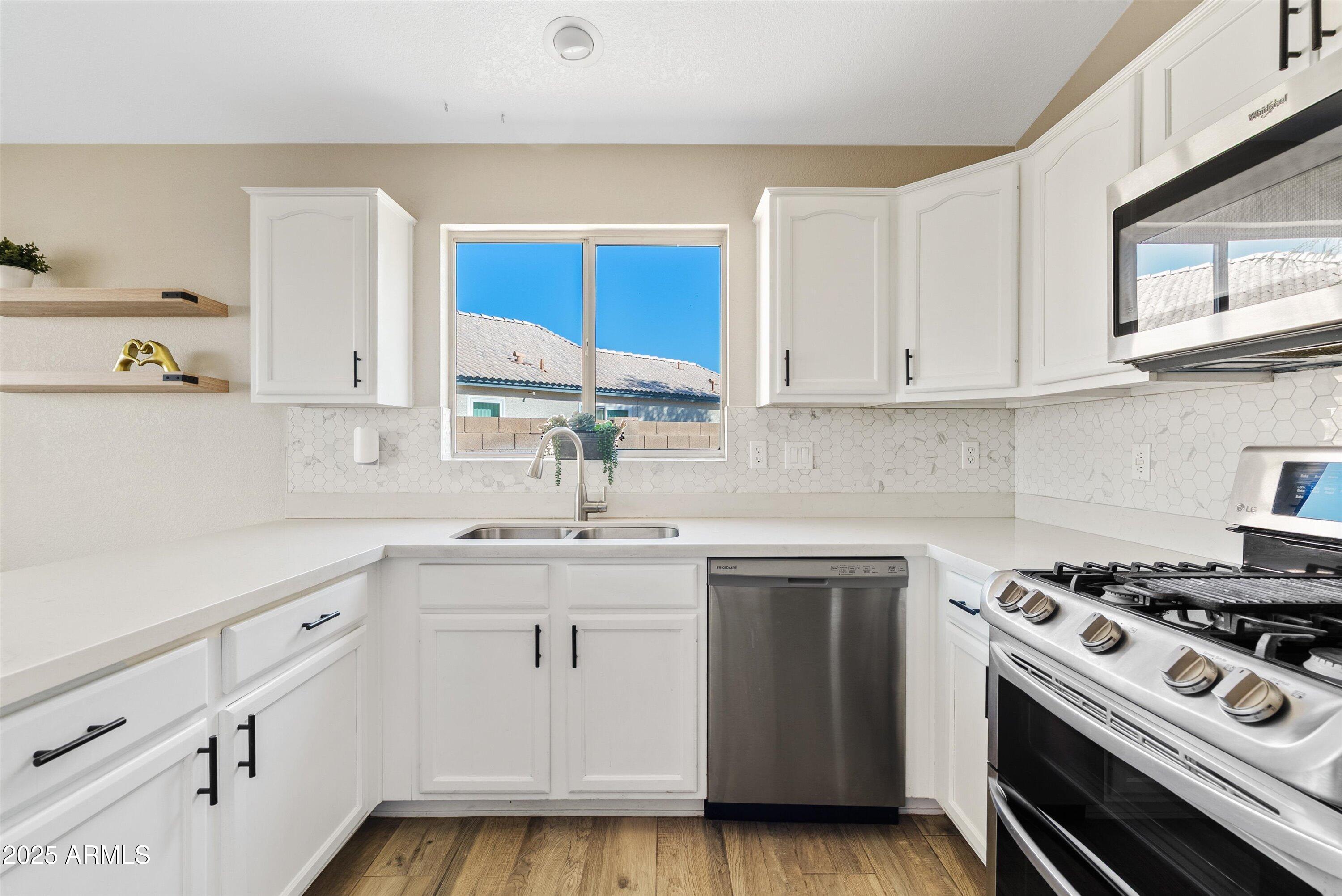 545 South Ash Street Gilbert, AZ 85233 - Photo 9 of 38 a kitchen with white cabinets sink and appliances