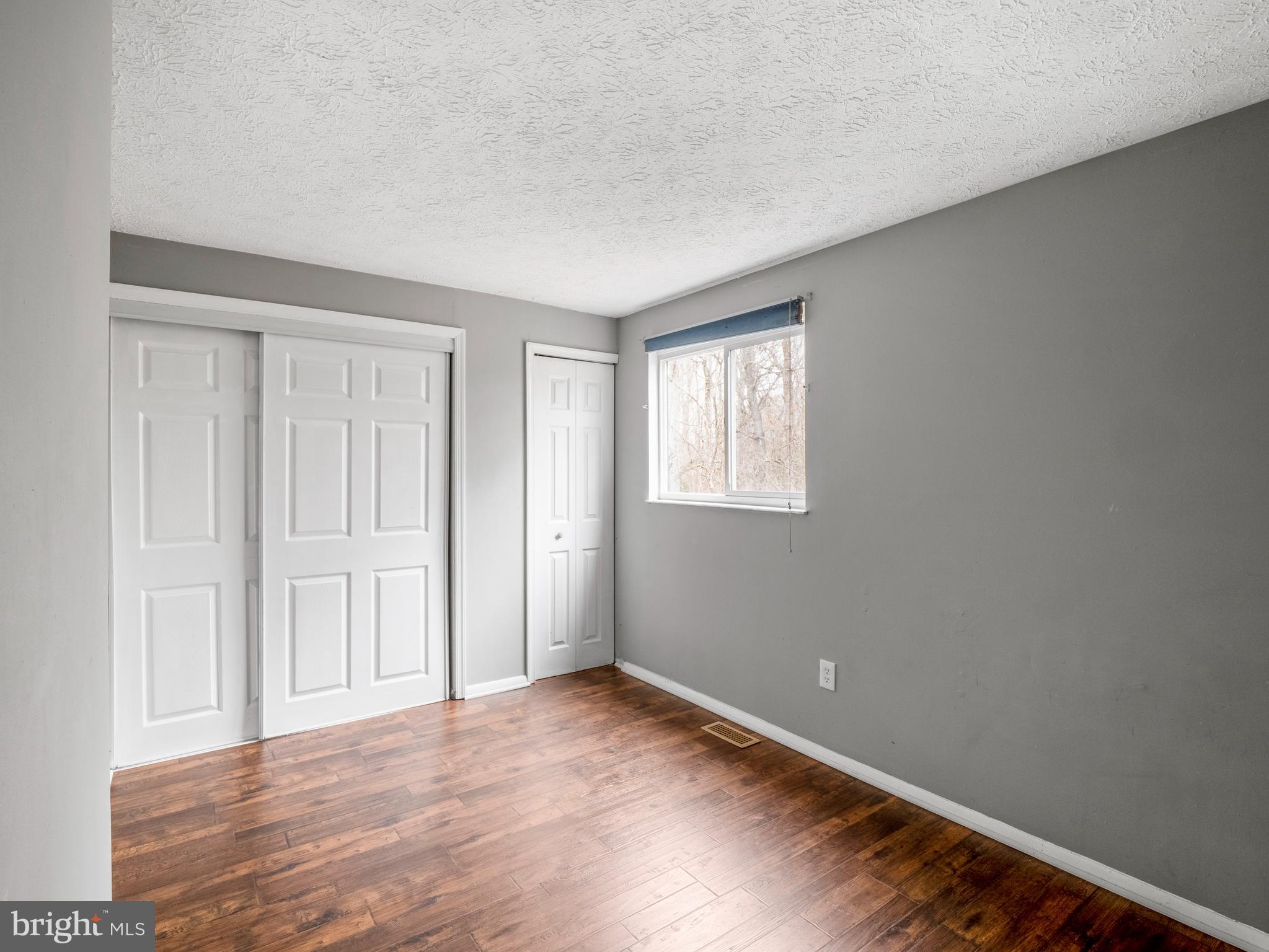 8315 Brookvale Court Springfield, VA 22153 - Photo 18 of 24 a view of an empty room with wooden floor and a window