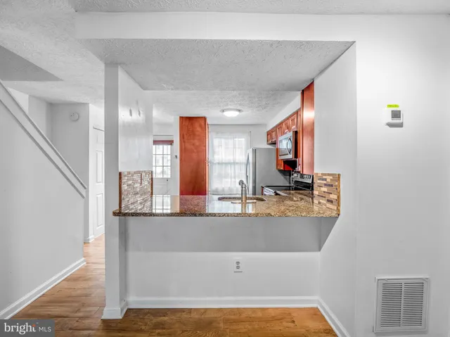 a view of a kitchen with kitchen island stainless steel appliances wooden floor and window
