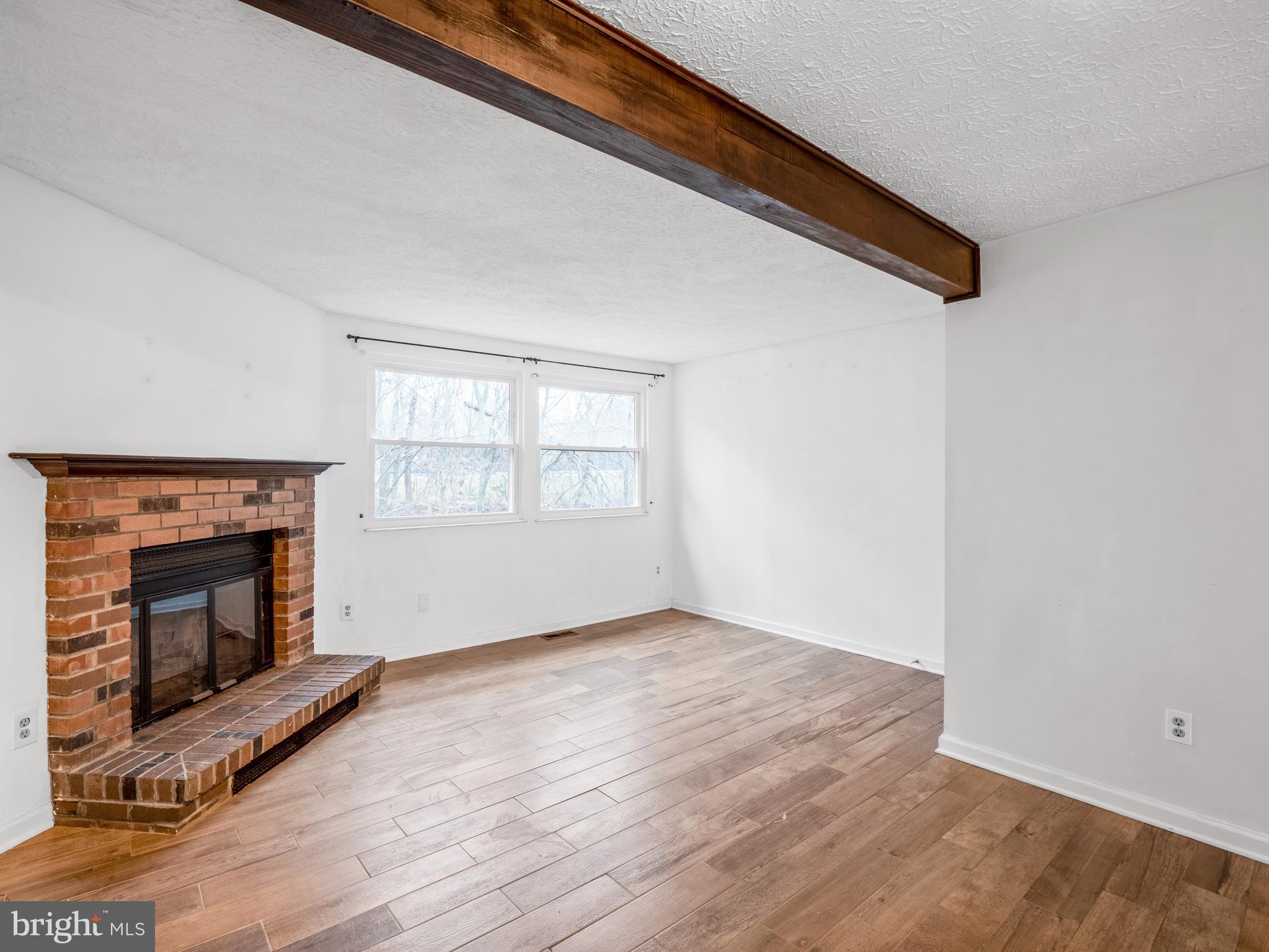 8315 Brookvale Court Springfield, VA 22153 - Photo 8 of 24 an empty room with wooden floor fireplace and windows
