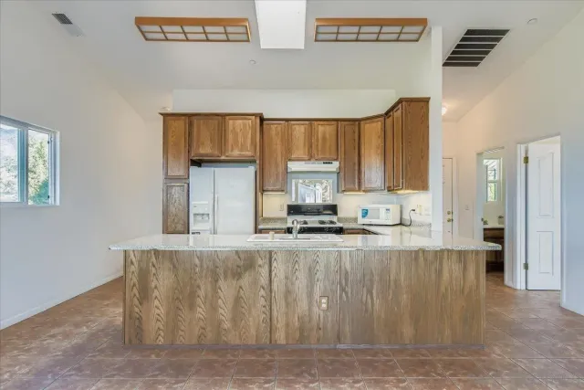 a kitchen with stainless steel appliances granite countertop a stove a sink and a refrigerator