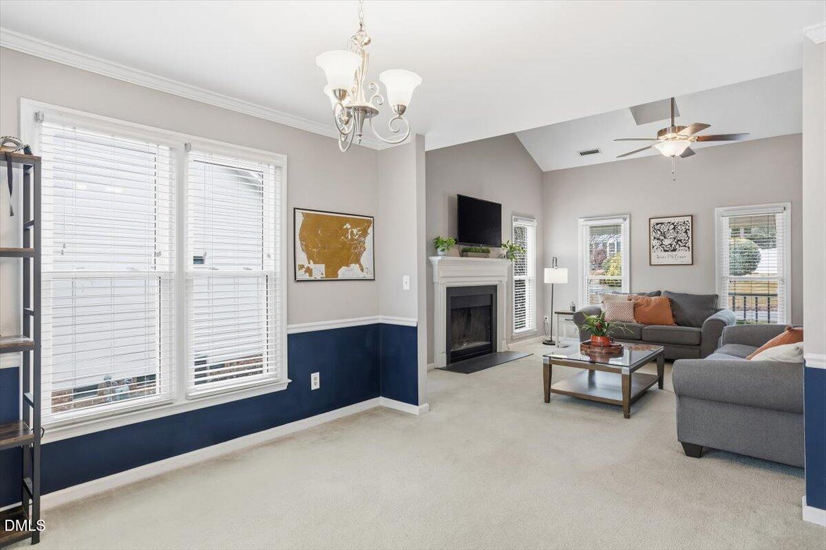 211 Kronos Lane Cary, NC 27513 - Photo 14 of 34 a living room with furniture a fireplace and a flat screen tv