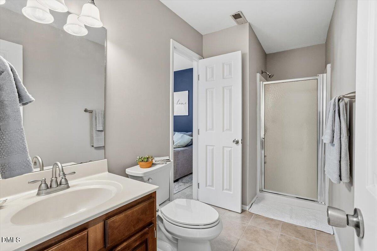 211 Kronos Lane Cary, NC 27513 - Photo 21 of 34 a bathroom with a sink a toilet and shower a mirror
