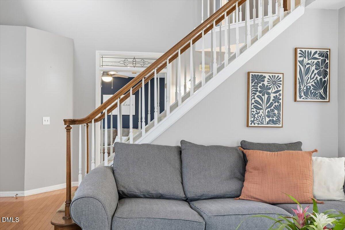 211 Kronos Lane Cary, NC 27513 - Photo 24 of 34 a living room with couches and a dining table with wooden floor