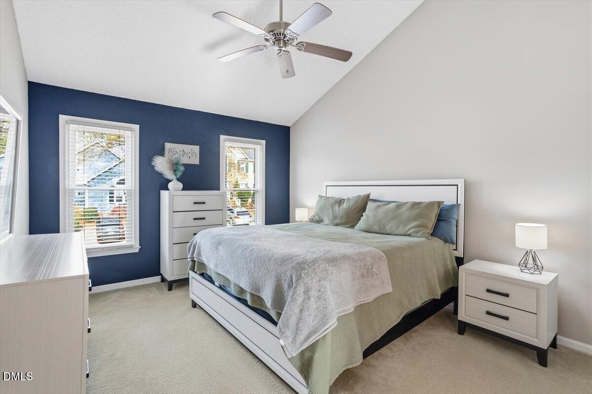 211 Kronos Lane Cary, NC 27513 - Photo 30 of 34 a spacious bedroom with a bed and a chandelier
