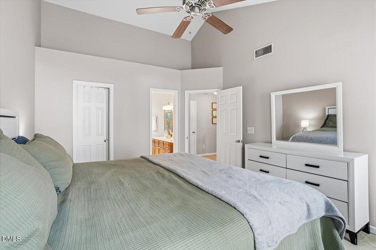 211 Kronos Lane Cary, NC 27513 - Photo 31 of 34 a spacious bedroom with a bed and a chandelier