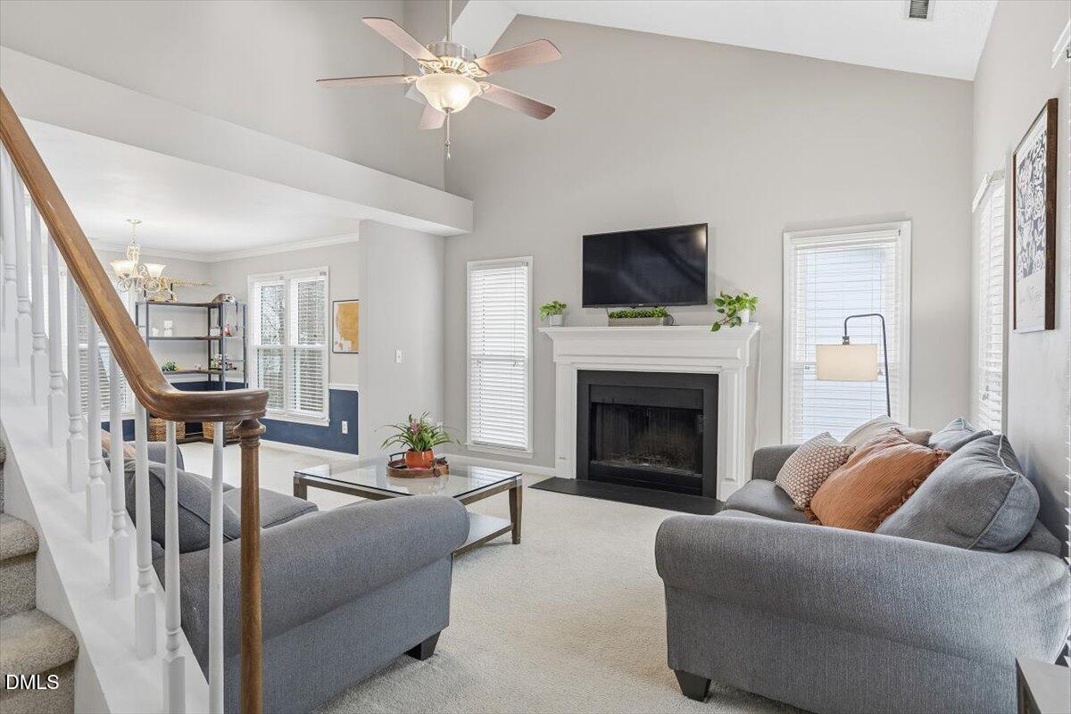 211 Kronos Lane Cary, NC 27513 - Photo 9 of 34 a living room with furniture a flat screen tv and a fireplace
