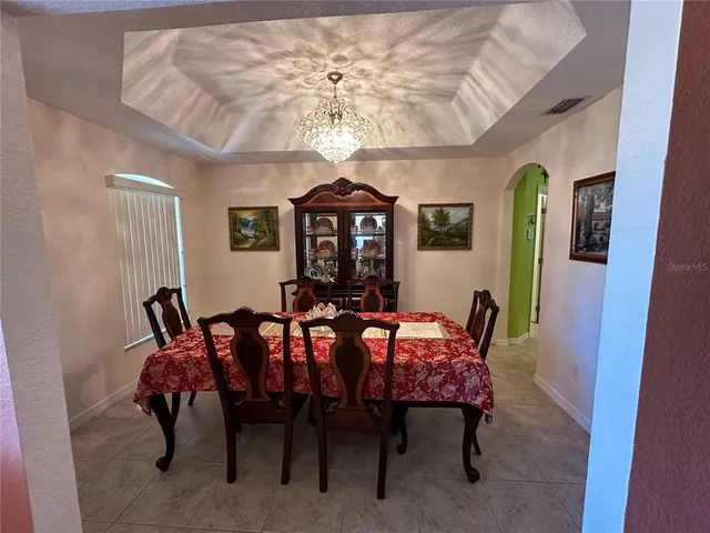 a view of a dining room with furniture and chandelier