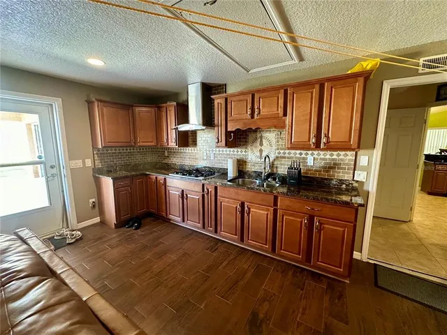 a kitchen with stainless steel appliances granite countertop a stove a sink dishwasher and a refrigerator