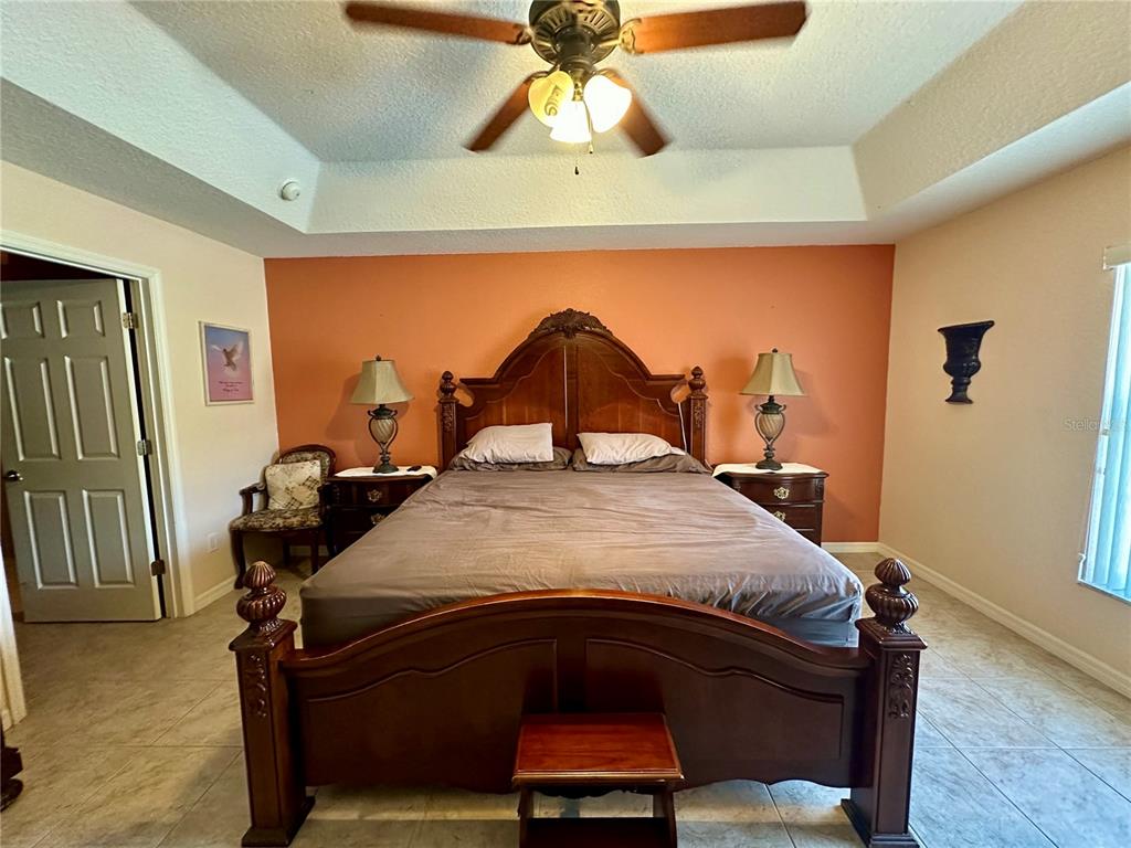 2576 Southwest 175 Loop Ocala, FL 34473 - Photo 25 of 62 a bedroom with a bed and a chandelier