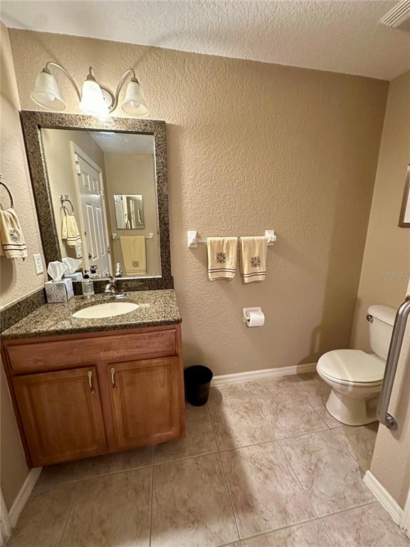 2576 Southwest 175 Loop Ocala, FL 34473 - Photo 37 of 62 a bathroom with a granite countertop sink mirror vanity and toilet