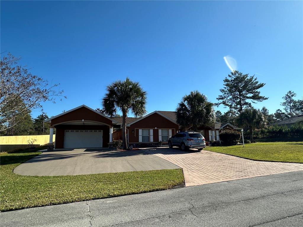 2576 Southwest 175 Loop Ocala, FL 34473 - Photo 4 of 62 a front view of a house with a yard and garage
