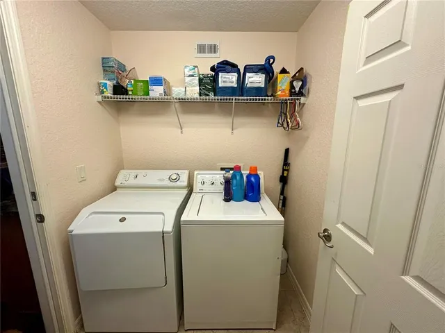 a view of a patio with table and chairs under an umbrella