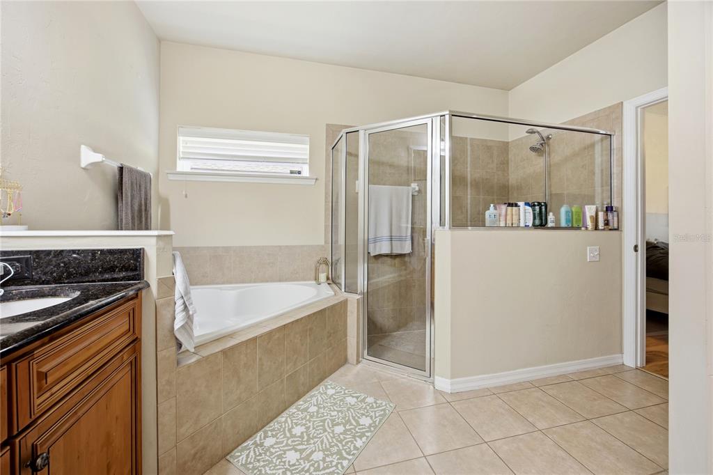 7550 Southwest 81st Way Gainesville, FL 32608 - Photo 19 of 31 a bathroom with a tub a mirror and a shower
