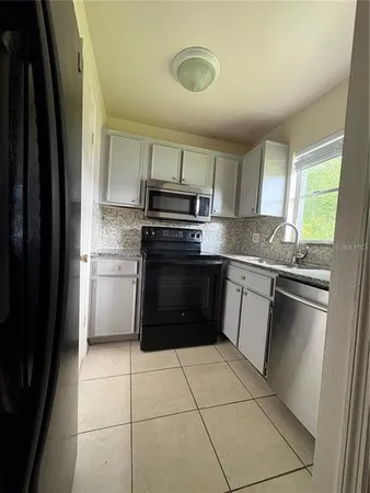 a kitchen with a stove a sink and a refrigerator