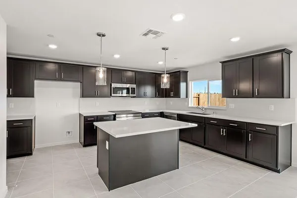 a kitchen with a sink a stove a refrigerator and a microwave