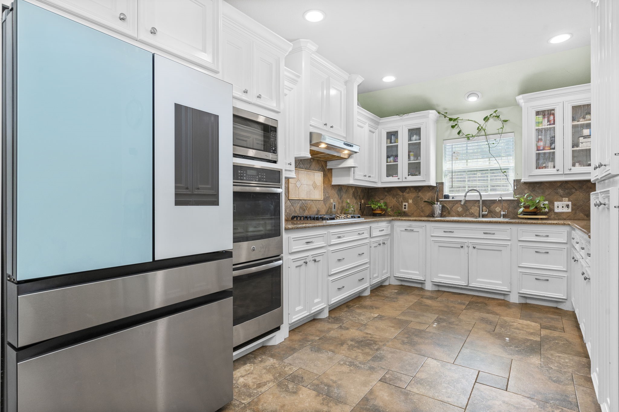 631 Apache Street Houston, TX 77022 - Photo 25 of 45 a large kitchen with cabinets and stainless steel appliances