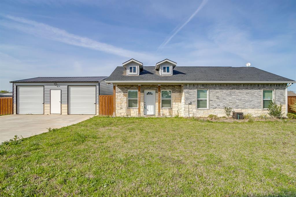 604 South Aquilla Street Itasca, TX 76055 - Photo 1 of 1 a front view of a house with a garden and yard