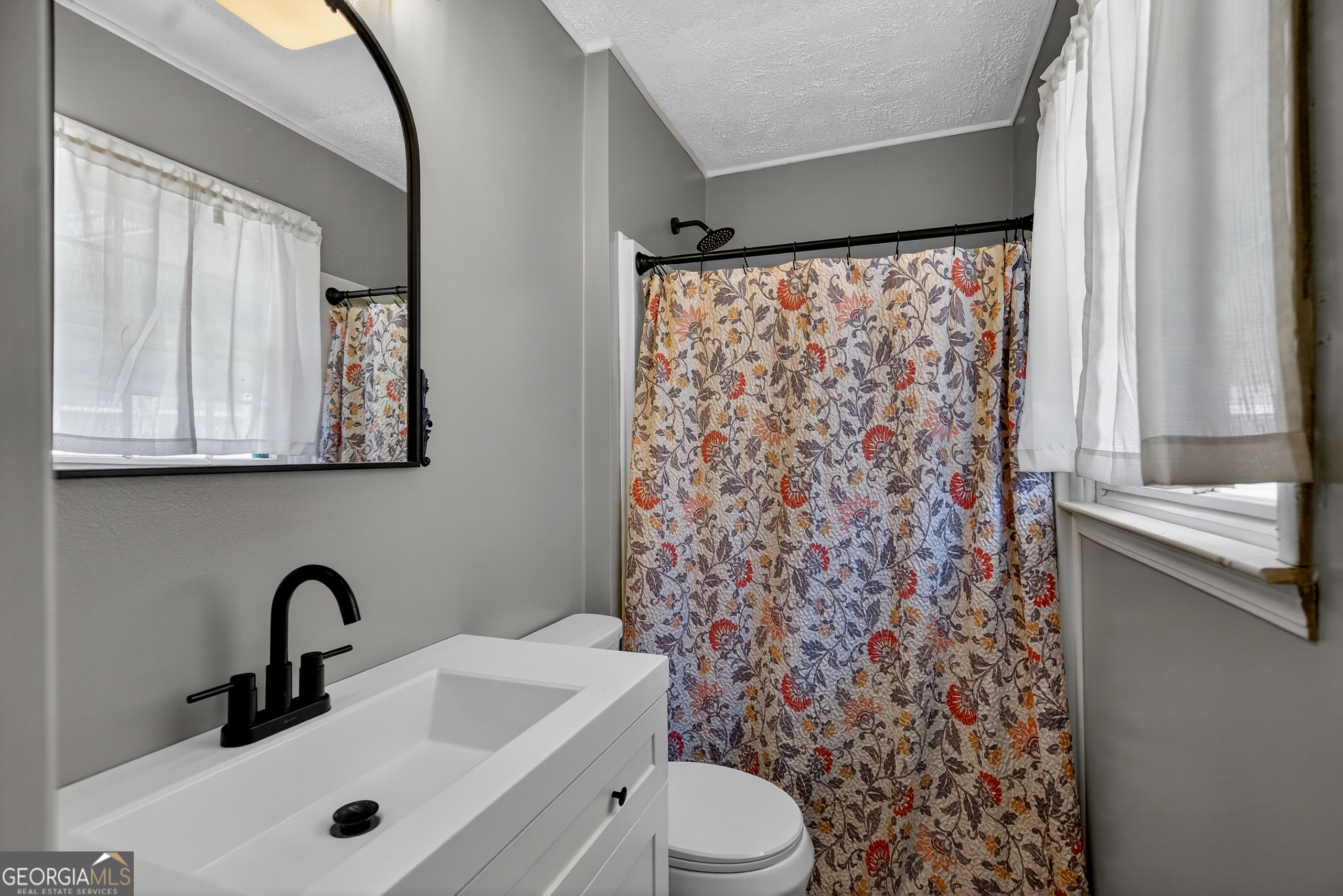 2404 19th Avenue Valley, AL 36854 - Photo 19 of 24 a bathroom with a sink a toilet and a mirror
