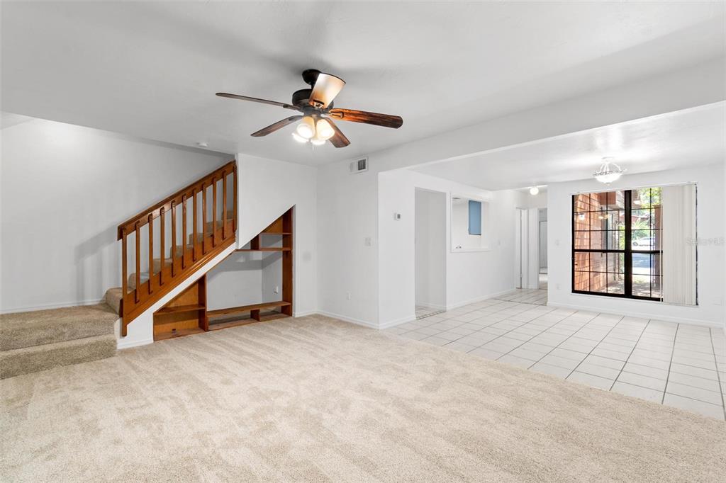 5606 Southwest 8th Place Gainesville, FL 32607 - Photo 11 of 24 a view of an empty room with wooden floor and a ceiling fan