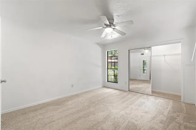 an empty room with fan and windows