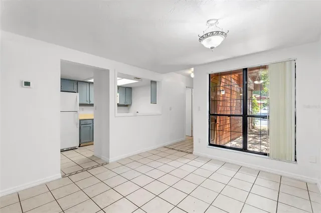 a view of an empty room with window and chandelier