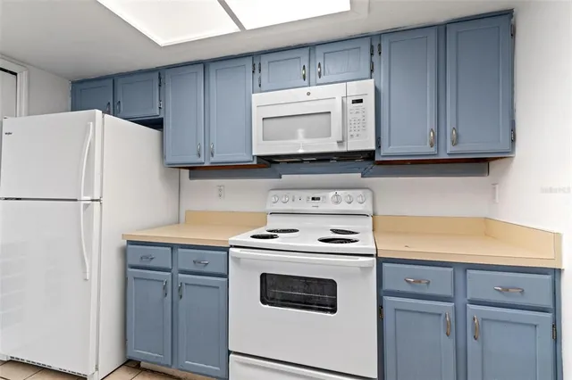 a kitchen with a stove and a refrigerator with wooden cabinets