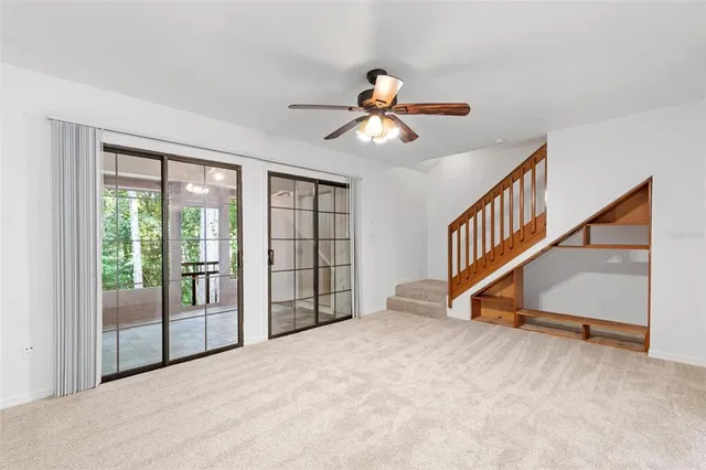 a view of empty room with stairs and windows