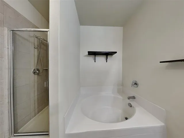a white bath tub sitting next to a shower