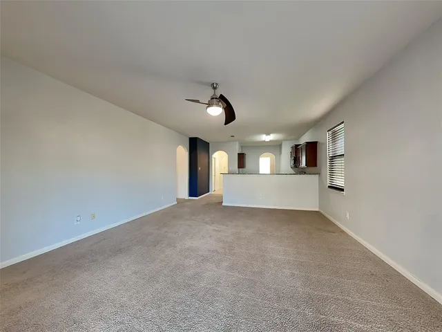 a view of empty room with a ceiling fan and window