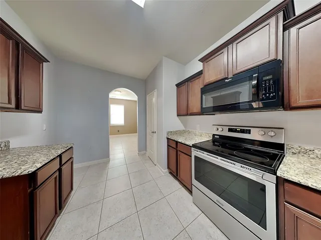 a kitchen with stainless steel appliances granite countertop a stove microwave and sink
