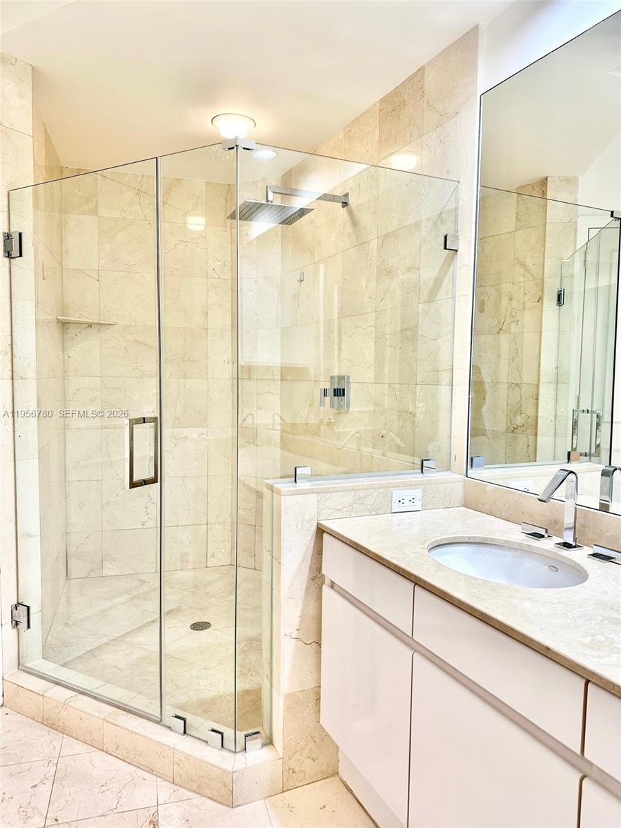 808 Brickell Key Drive, Unit 3304 Miami, FL 33131 - Photo 15 of 60 a bathroom with a shower sink and mirror