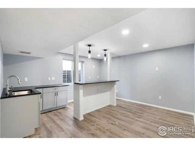 a kitchen with granite countertop a stove a sink and a refrigerator