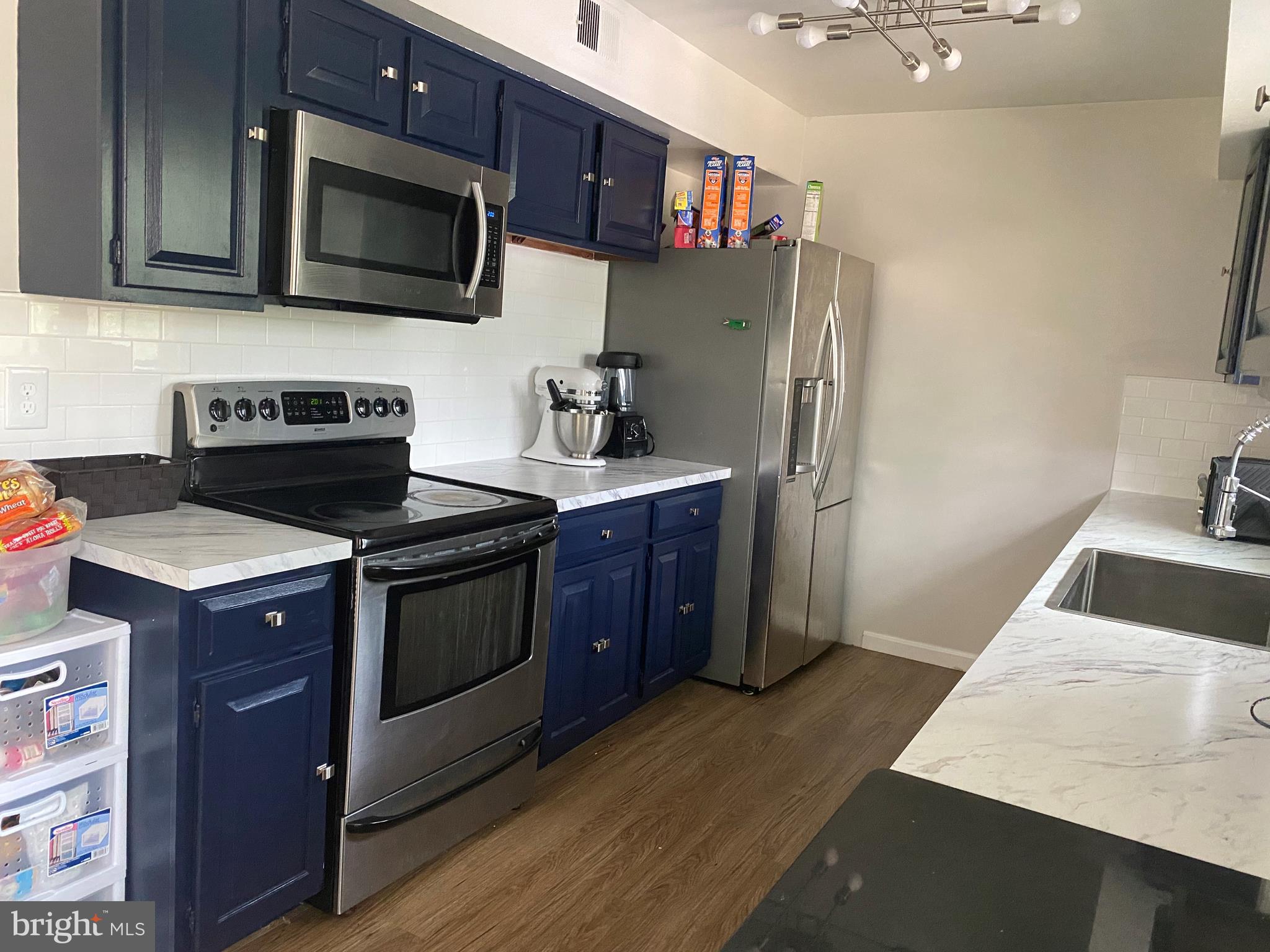 14526 Banquo Terrace, Unit 72 Silver Spring, MD 20906 - Photo 11 of 24 a kitchen with stainless steel appliances a stove a microwave a sink and cabinets