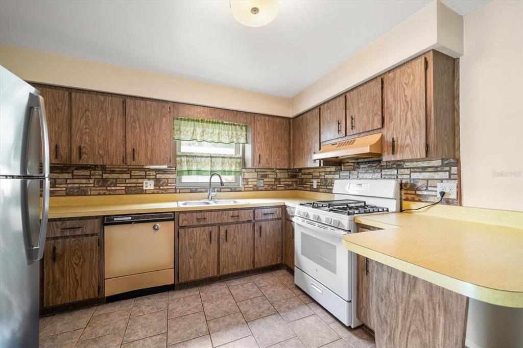 2850 Spring Lake Drive Clearwater, FL 33759 - Photo 11 of 37 a kitchen with stainless steel appliances granite countertop a sink and cabinets