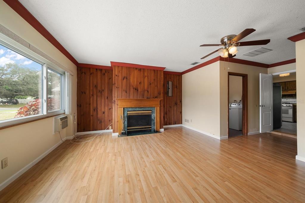 2850 Spring Lake Drive Clearwater, FL 33759 - Photo 3 of 37 a view of a livingroom with wooden floor a ceiling fan and windows