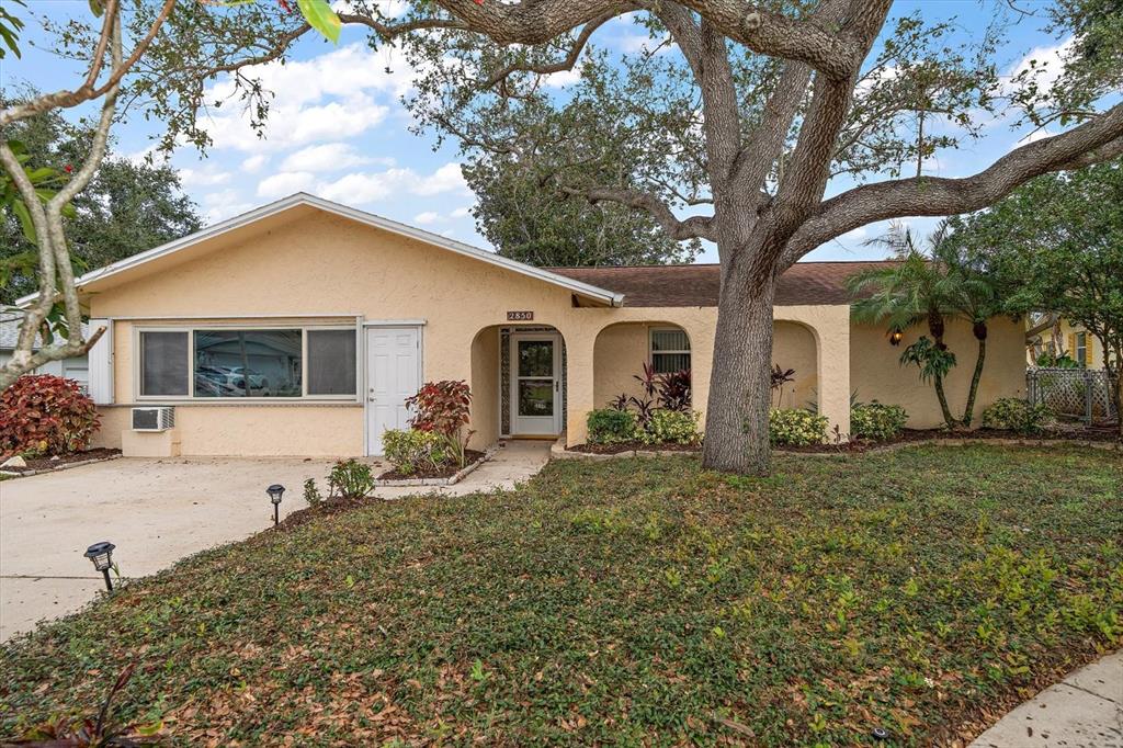 2850 Spring Lake Drive Clearwater, FL 33759 - Photo 34 of 37 a front view of a house with a yard and trees