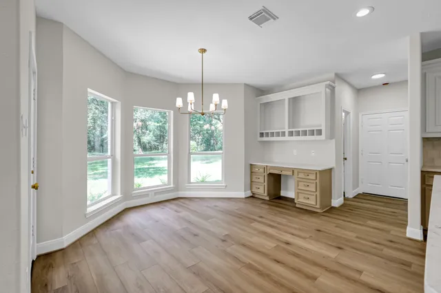 a view of a room with wooden floor fireplace and windows