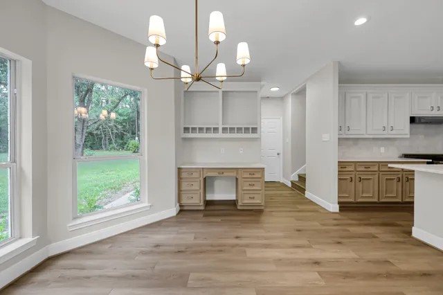 a kitchen with stainless steel appliances granite countertop a stove a refrigerator a oven with white cabinets and wooden floor