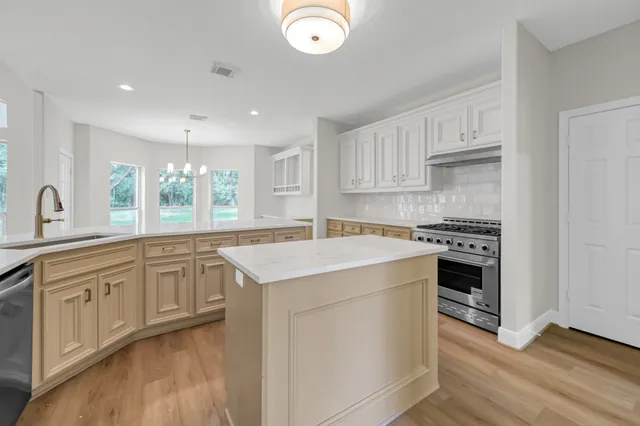 a kitchen with granite countertop white cabinets and white appliances