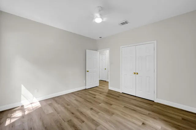 a view of an empty room with wooden floor