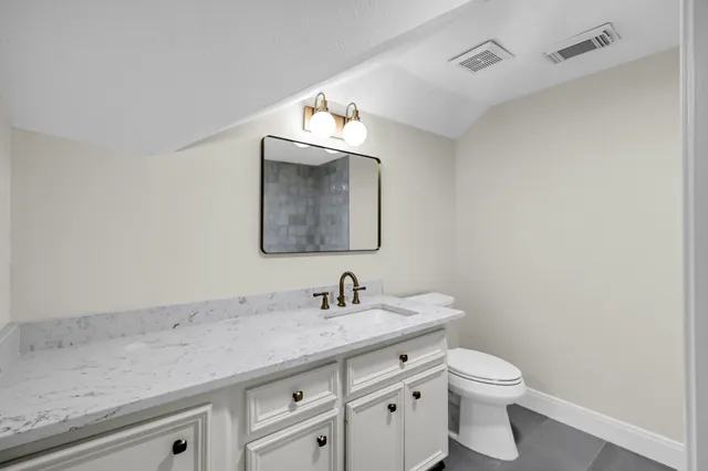 a bathroom with a toilet sink and mirror