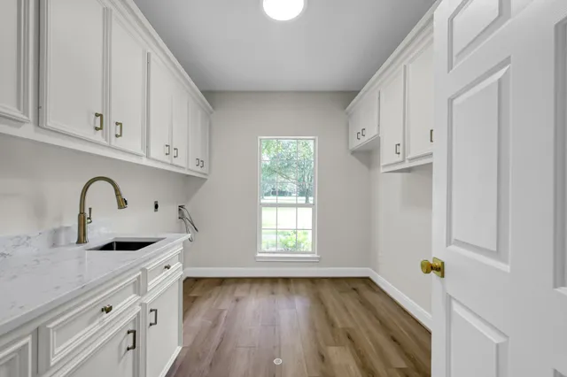 a kitchen with granite countertop white cabinets and window