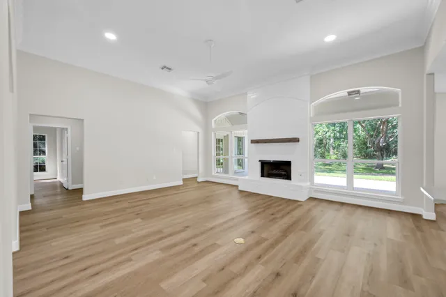 a view of empty room with wooden floor and fireplace